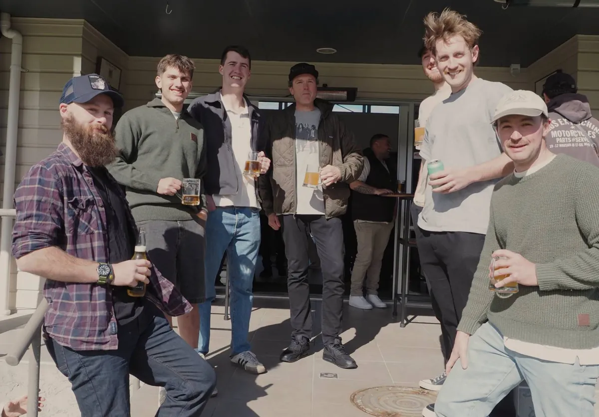 A group of friends enjoying drinks in the sun outside the clubhouse