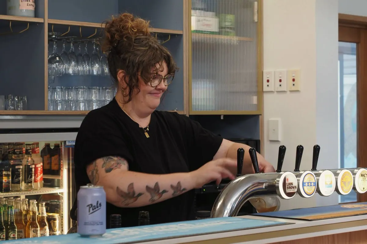 Bar staff pouring a beer from the taps